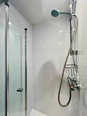 a shower with a shower head in a bathroom at Unique Suffolk Cabin with Countryside Views in Burgh