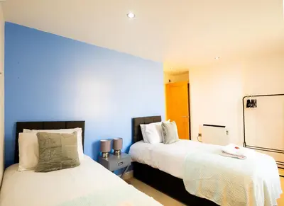 two beds in a room with blue walls at Cozy 2BR 2BATH Apt in Central Ipswich - Sleeps 6 & Prime Location in Ipswich