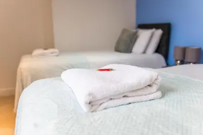 a pile of towels sitting on top of a bed at Cozy 2BR 2BATH Apt in Central Ipswich - Sleeps 6 & Prime Location in Ipswich