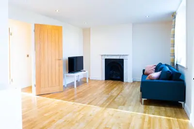 a living room with a blue couch and a television at Cozy 2BR 2BATH Apt in Central Ipswich - Sleeps 6 & Prime Location in Ipswich
