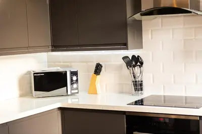 a kitchen counter with a microwave and utensils at Cozy 2BR 2BATH Apt in Central Ipswich - Sleeps 6 & Prime Location in Ipswich