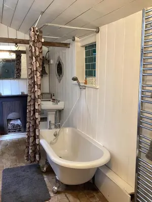 a white bath tub in a bathroom with a sink at The Eclectic Coach House in Roydon