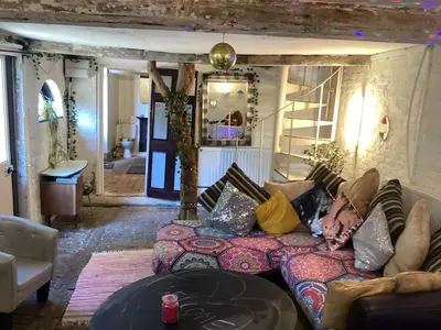 a living room with a couch and a table at The Eclectic Coach House in Roydon