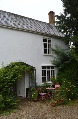 a white house with a table and chairs at Countryside Tiny House in Roydon