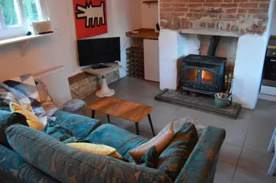 a living room with a couch and a fireplace at Countryside Tiny House in Roydon