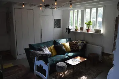 a living room with a blue couch and a table at Countryside Tiny House in Roydon