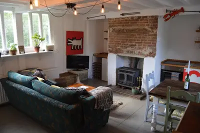 a living room with a couch and a fireplace at Countryside Tiny House in Roydon