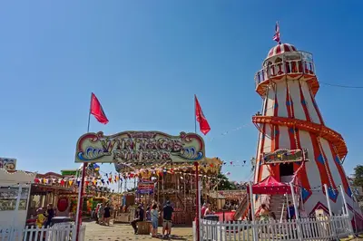 a carnival with a ferris wheel and a ride at Cosy Caravan With Decking At Oaklands Holiday Park In Essex Ref 39042Cf in Clacton-on-Sea