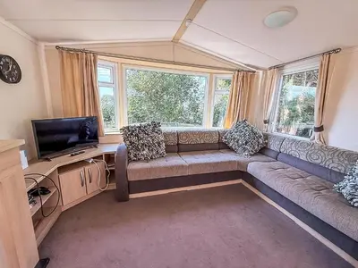 a living room with a couch and a television at Cosy Caravan With Decking At Oaklands Holiday Park In Essex Ref 39042Cf in Clacton-on-Sea