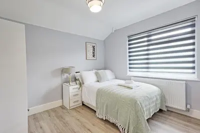 a white bedroom with a bed and a window at 5 Bedroom Apartment - Weekly Deal - By Homestyles Hosts Short Lets and Serviced Accommodation Widford - Free Parking in Writtle