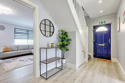 a living room with a blue door and a plant at 5 Bedroom Apartment - Weekly Deal - By Homestyles Hosts Short Lets and Serviced Accommodation Widford - Free Parking in Writtle