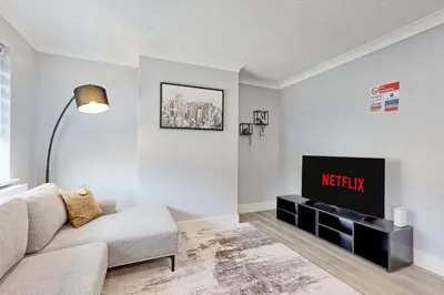 a living room with a couch and a tv at 5 Bedroom Apartment - Weekly Deal - By Homestyles Hosts Short Lets and Serviced Accommodation Widford - Free Parking in Writtle