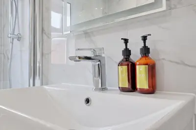 two bottles of soap are sitting on a bathroom sink at Studio By Homestyles Hosts Short Lets & Serviced Accommodation Widford - Free WiFi in Writtle