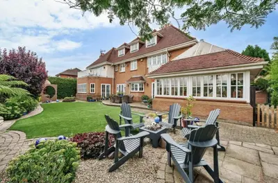 a house with chairs and a table in the yard at Relaxing Coastal Getaway Perfect for Families in Canvey Island