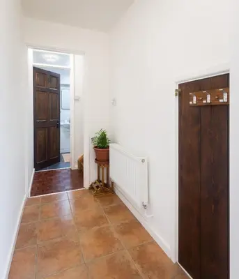 a hallway with a door and a tile floor at Lazy Acre, Suffolk in Hopton