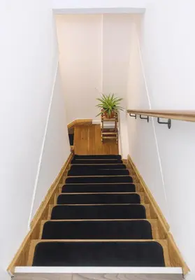 a staircase in a building with a potted plant at Lazy Acre, Suffolk in Hopton