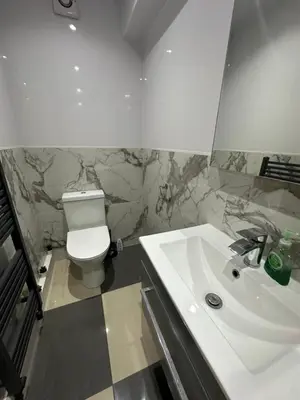 a bathroom with a white toilet and a sink at A Comfortable and Cosy Self Contained Room in Navestock