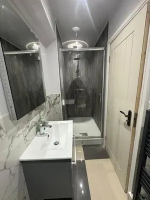 a bathroom with a white sink and a shower at A Comfortable and Cosy Self Contained Room in Navestock
