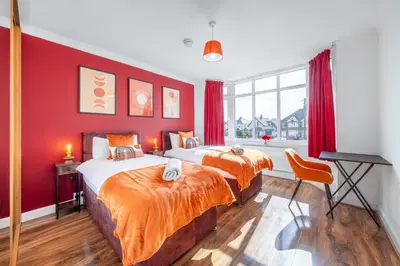 two beds in a room with red walls at Free parking - 6 Bedroom Home in Colchester