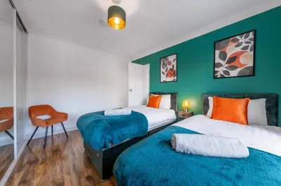 two beds in a room with green walls at Free parking - 6 Bedroom Home in Colchester