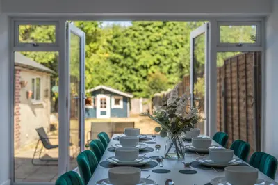 a table with cups and saucers on it in a room at Free parking - 6 Bedroom Home in Colchester