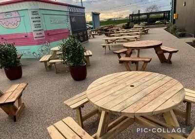 a group of picnic tables and benches in a cafeteria at Seaside caravan in Clacton-on-Sea