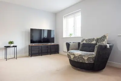 a living room with a chair and a flat screen tv at 3bed town house- Superking Beds-fast WI-FI-Parking in Colchester
