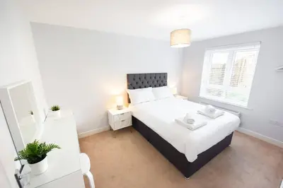 a bedroom with a large bed and a window at 3bed town house- Superking Beds-fast WI-FI-Parking in Colchester