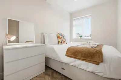a white bedroom with a bed and a window at 2 Royal Serviced Apartments, Ground Floor, two Bed,Fast Wifi - Space in Parkeston