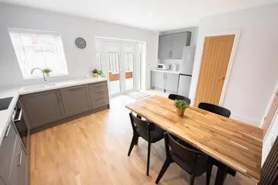 a kitchen and dining room with a wooden table and chairs at 3 Bed 2.5 Bath Detached House,Parking,Pet Friendly in Parkeston
