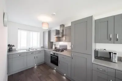 a kitchen with white cabinets and stainless steel appliances at House -Superking Beds-Garden-FastWifi-Pet Friendly in Broomfield