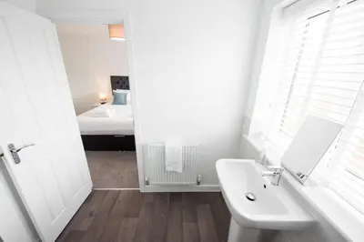 a white bathroom with a sink and a bed at House -Superking Beds-Garden-FastWifi-Pet Friendly in Broomfield