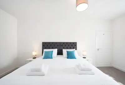 a bedroom with a large white bed with blue pillows at House -Superking Beds-Garden-FastWifi-Pet Friendly in Broomfield