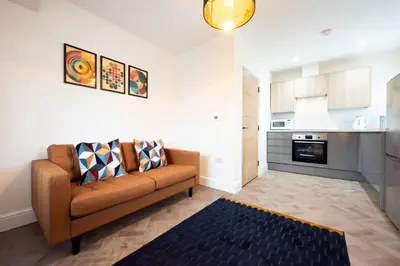a living room with a couch and a kitchen at 7 The Royal Serviced Apartments Harwich, Fair WiFi, Private Parking in Parkeston