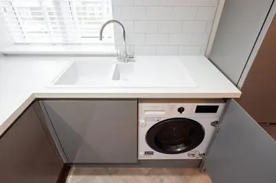 a kitchen with a sink and a washing machine at 7 The Royal Serviced Apartments Harwich, Fair WiFi, Private Parking in Parkeston