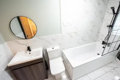 a bathroom with a toilet and a sink and a mirror at 7 The Royal Serviced Apartments Harwich, Fair WiFi, Private Parking in Parkeston