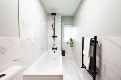 a white bathroom with a tub and a sink at 7 The Royal Serviced Apartments Harwich, Fair WiFi, Private Parking in Parkeston