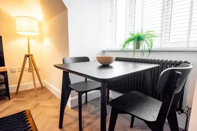 a black table and chairs in a room with a window at 7 The Royal Serviced Apartments Harwich, Fair WiFi, Private Parking in Parkeston