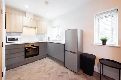a kitchen with a stainless steel refrigerator and a window at 7 The Royal Serviced Apartments Harwich, Fair WiFi, Private Parking in Parkeston