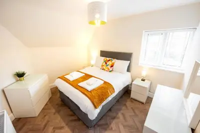 a bedroom with a bed with two towels on it at 6 The Royal Serviced Apartments, Harwich - Fast WiFi, Private Parking in Parkeston