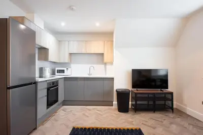 a kitchen with a sink and a tv in it at 6 The Royal Serviced Apartments, Harwich - Fast WiFi, Private Parking in Parkeston