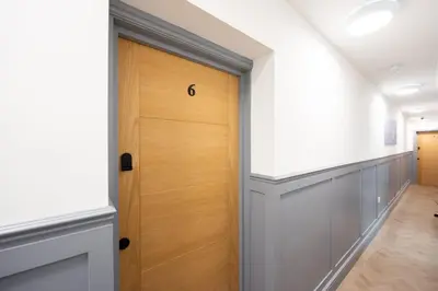 a hallway with a wooden door in a building at 6 The Royal Serviced Apartments, Harwich - Fast WiFi, Private Parking in Parkeston