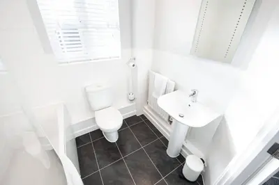 a white bathroom with a toilet and a sink at Two Double Bed Coach House with Parking Fast WiFi in Colchester