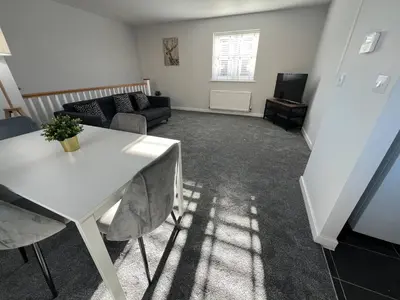 a living room with a white table and a couch at Two Double Bed Coach House with Parking Fast WiFi in Colchester