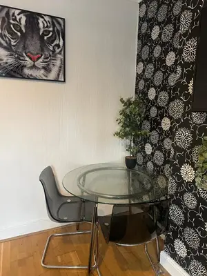 a glass table in a room with a picture of a tiger at The Retreat On Retreat Road in Southend-on-Sea