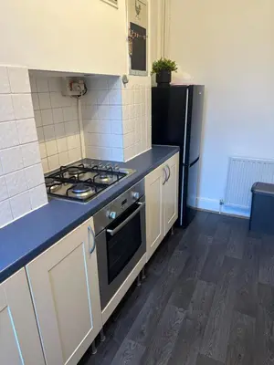 a kitchen with a stove and a black refrigerator at The Retreat On Retreat Road in Southend-on-Sea