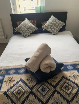 a bed with a blanket and a towel on it at 4 Bedroom House Colchester in Colchester