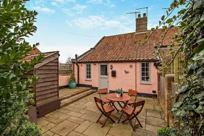 a patio with a table and chairs in front of a house at 1 Bed in Snape oc-a30669 in Snape