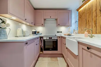 a kitchen with pink cabinets and white appliances at 1 Bed in Snape oc-a30669 in Snape