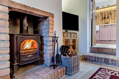 a brick fireplace in a kitchen with a stove at 1 Bed in Snape oc-a30669 in Snape